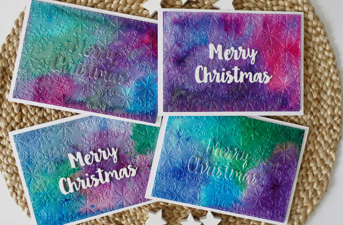 Handmade Christmas Holiday Card. Using Nuvo Shimmer Powders and Brusho Powders together with a snowflake embossing folder and Merry Christmas die cut sentiment from MFT. #cherrybeecards