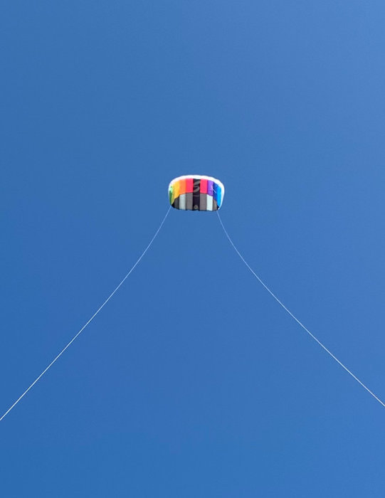 Flying our kite on a beautiful sunny day with clear blue skies.